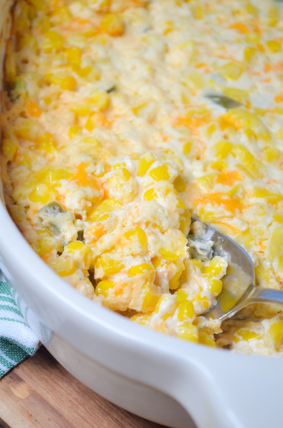 A spoon dishing into a baked casserole