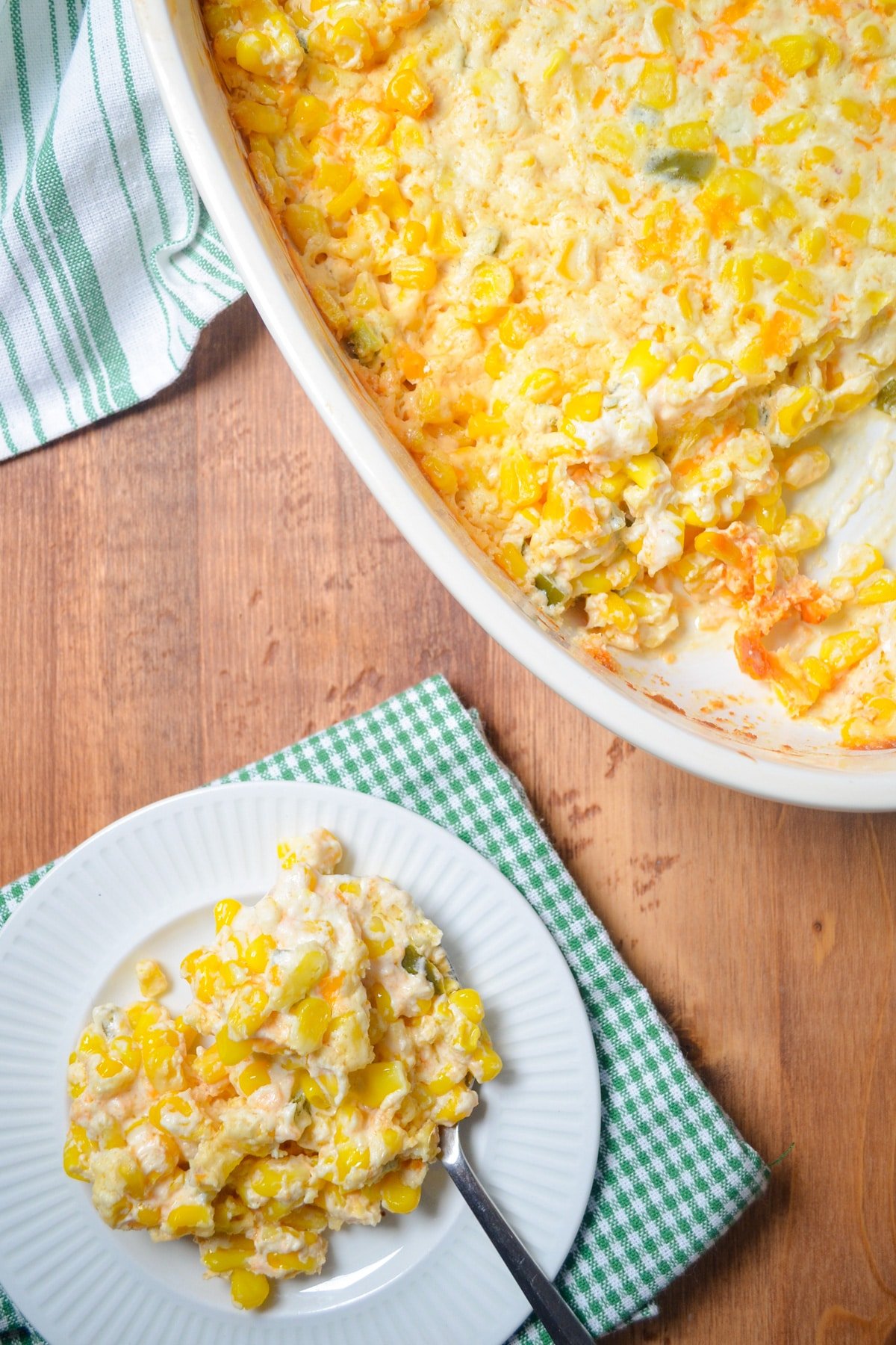 A plate full of corn casserole, with the serving dish nearby.