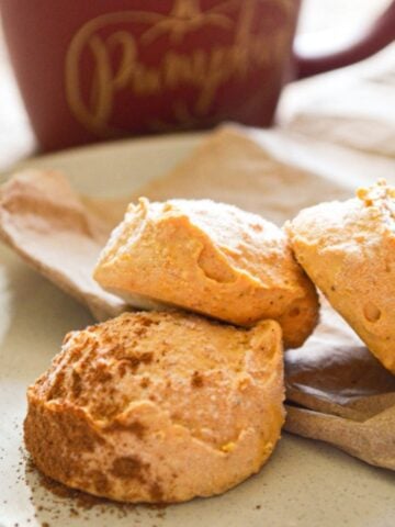 Pumpkin cheesecake bites, with a mug in the background.