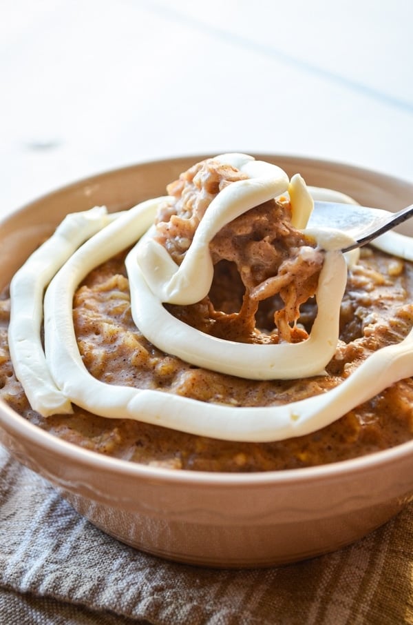 A spoon lifts a big spoonful of cinnamon roll oatmeal. 