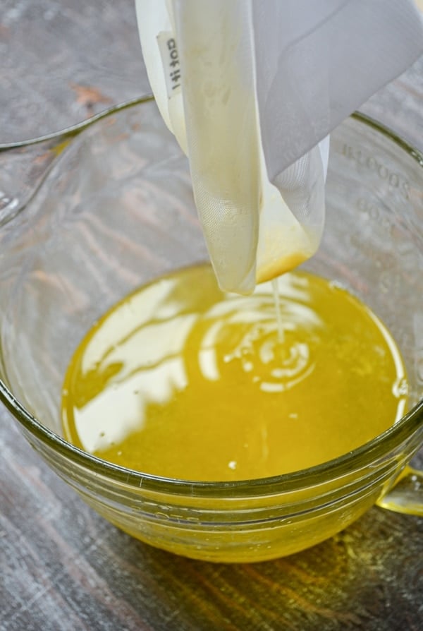 The milk solids are strained off using a nut milk bag, and a shimmering gold liquid (AKA ghee) is left behind.