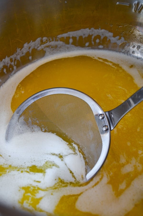 A skimming ladle is used to skim off the top layer of foam and milk solids from Instant Pot Homemade Ghee.
