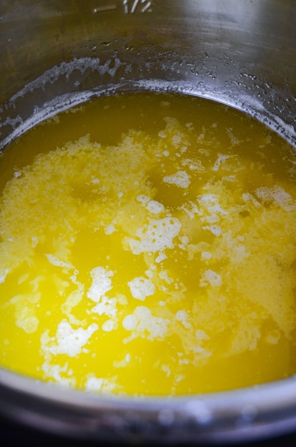 An instant pot, full of homemade ghee-in-process. The milk solids are starting to seperate.