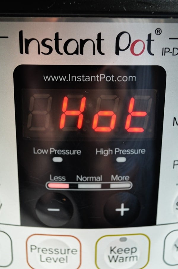 An Instant Pot with the digital screen reading "hot"