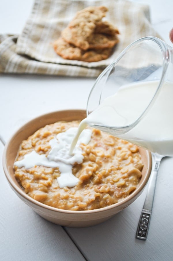 Milk being poured on a bowl of peanut butter cookie oatmeal. 