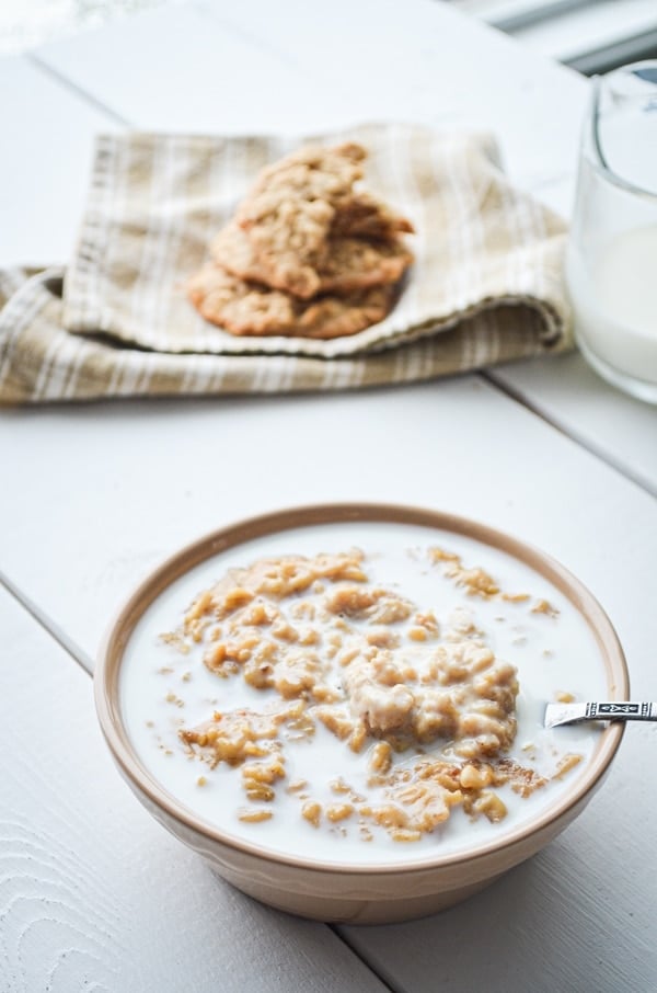 A bowl of peanut butter cookie oatmeal, served with plenty of milk.