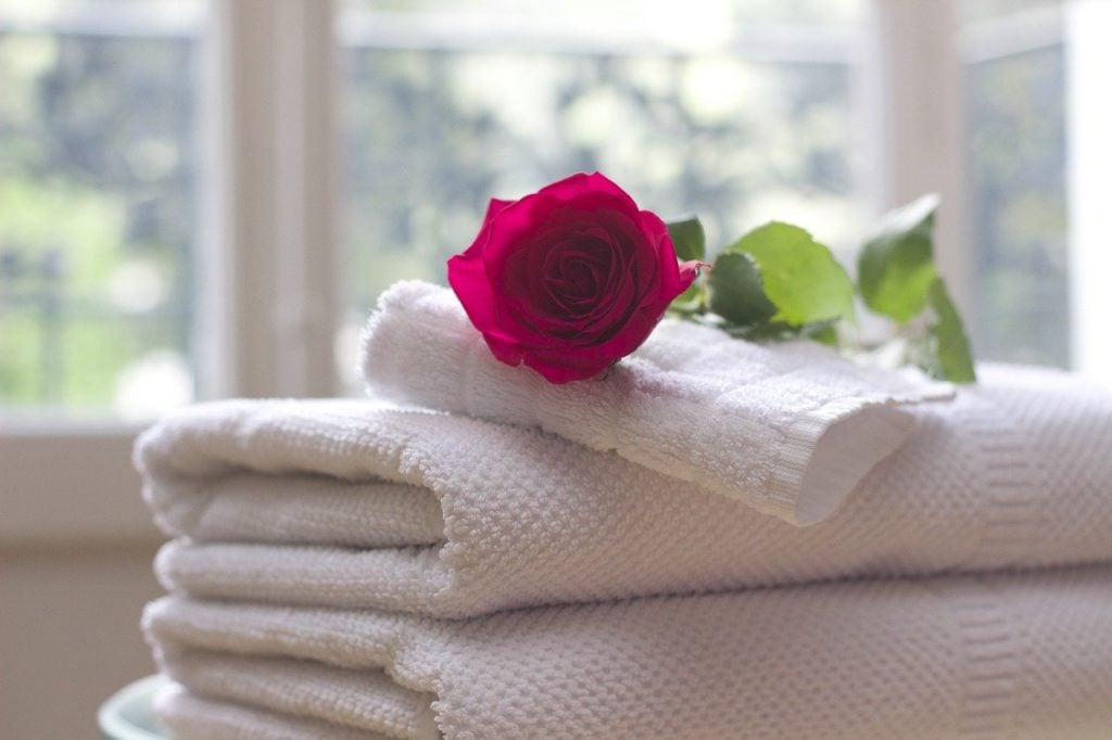 Towels folded with a rose on top.