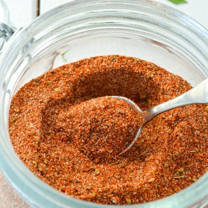 A jar of chicken taco seasoning with a small spoon inside.
