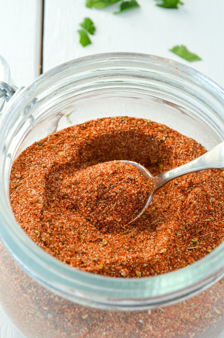 A jar of chicken taco seasoning with a small spoon inside.