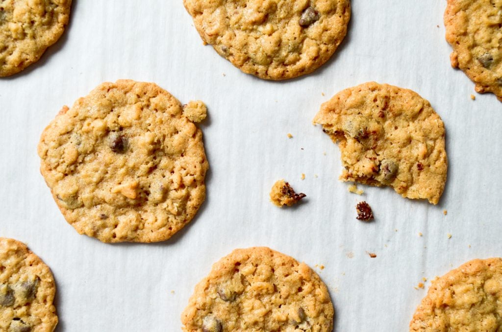 An overhead view of cookies, with a few crumbs of chocolate chip dough.