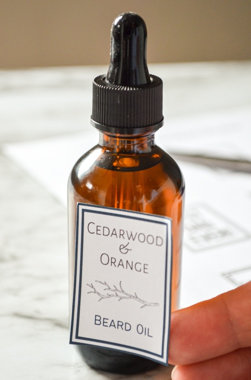 A label being applied to a bottle of Cedarwood and Orange Father's Day Beard Oil.