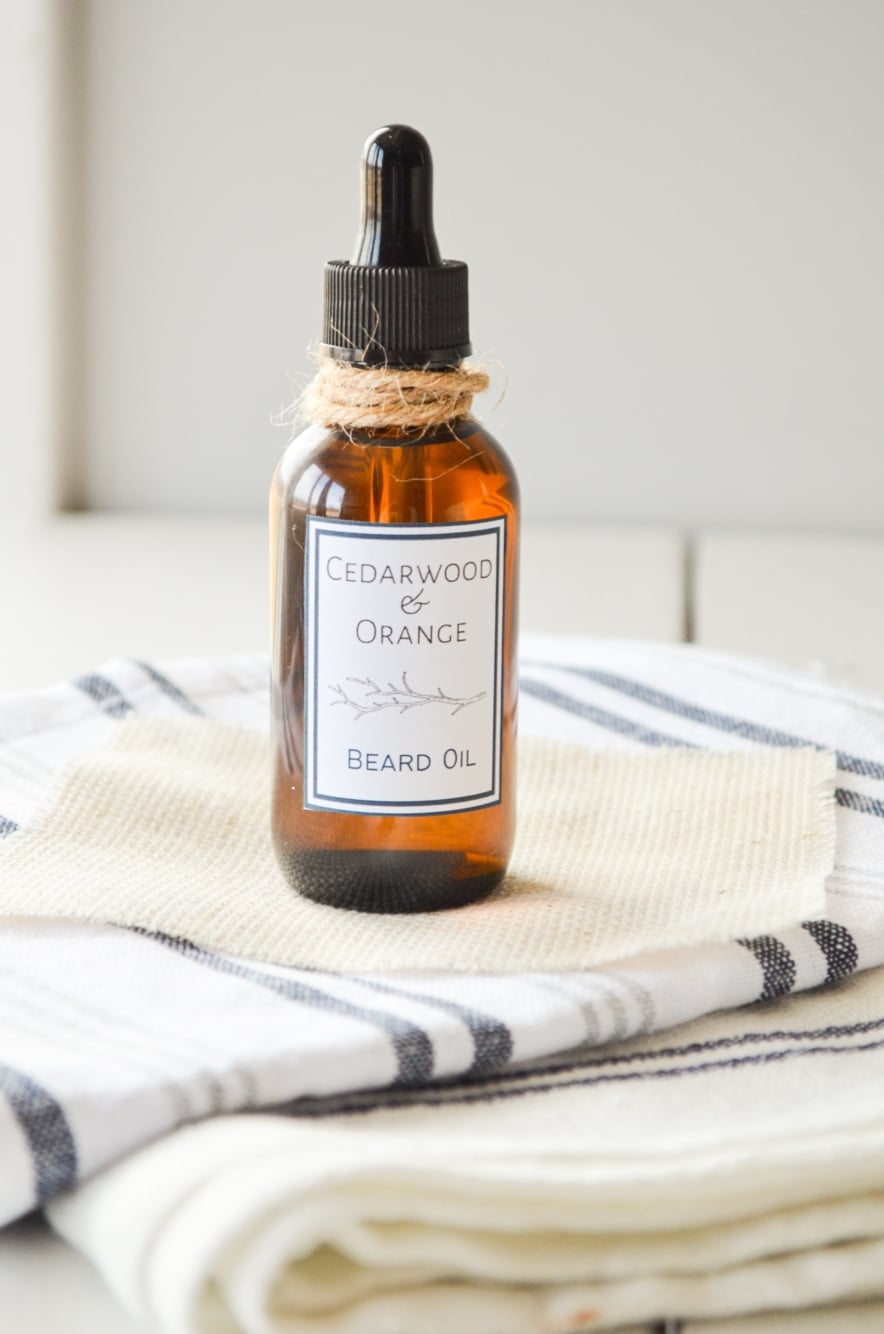 A bottle of fathers day beard oil, resting on several cloth napkins.