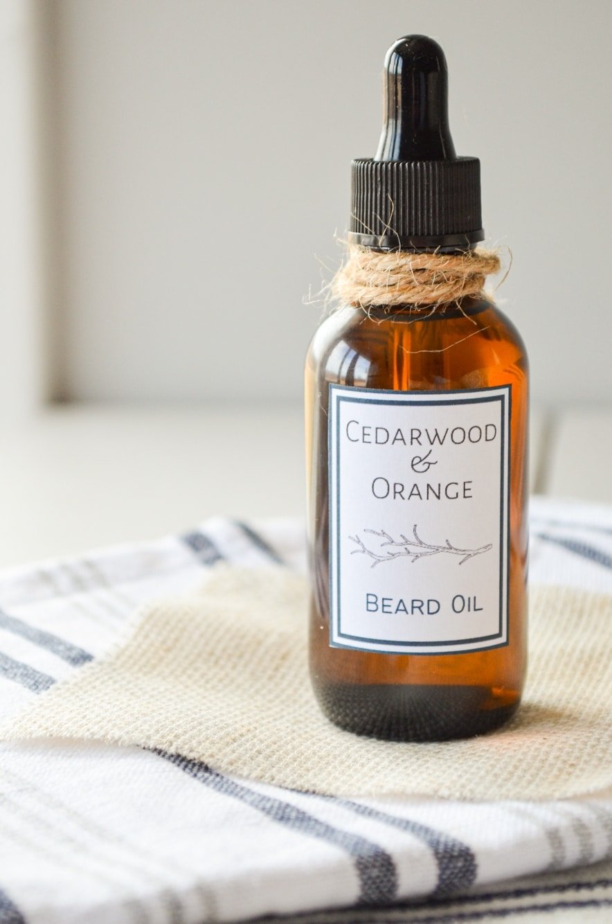 A bottle of Cedarwood and Orange beard oil. Placed on top of several cloth napkins and tied with a piece of twine.
