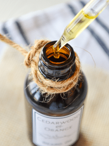 An oil dropper at the top of an amber bottle of beard oil. A bit of twine wrapped around the top.