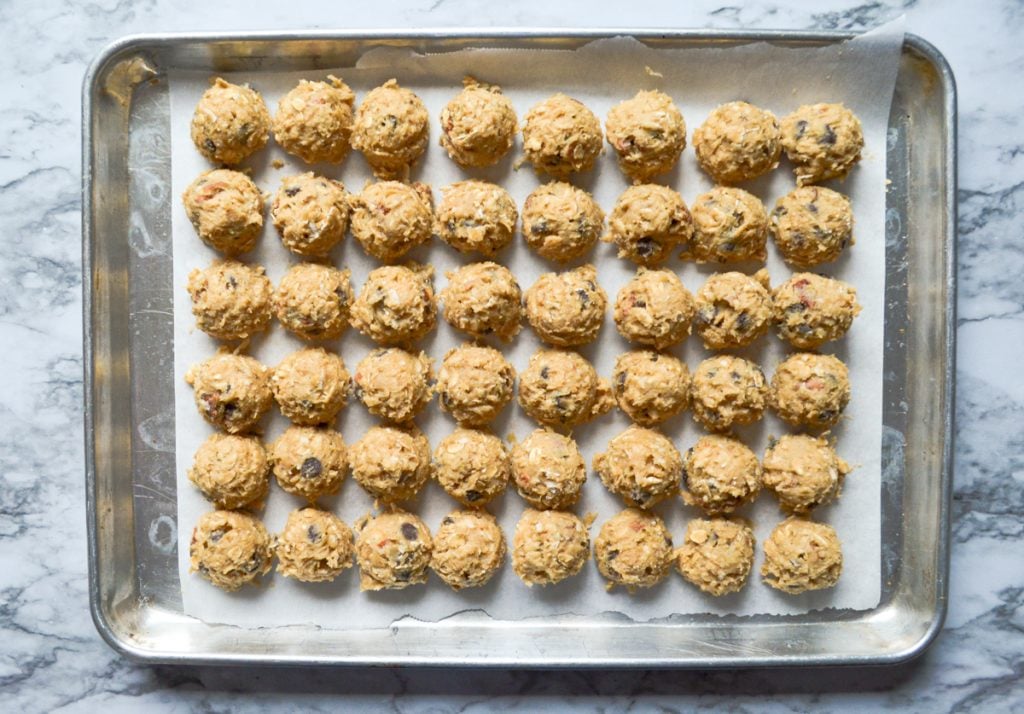 A baking sheet full of portioned buffalo chip cookie dough.