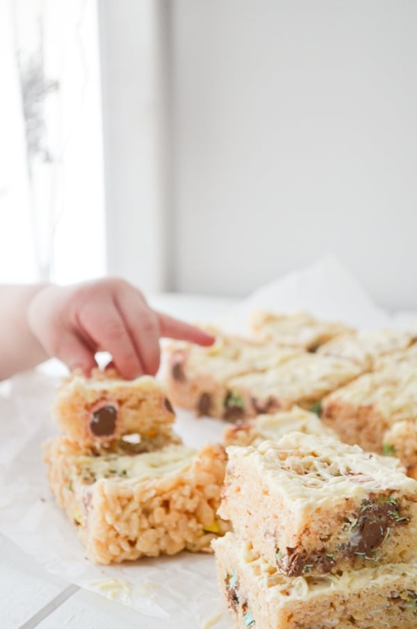 A toddler hand reaches in to grab a rice krispie treat.