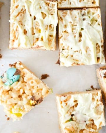 A top view of rice krispie treats with mini eggs, and drizzled with white chocolate.