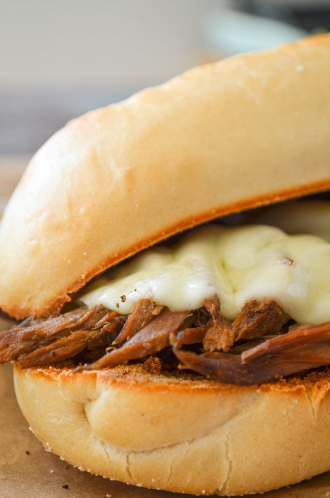 A french dip sandwich, featuring melted provolone cheese.