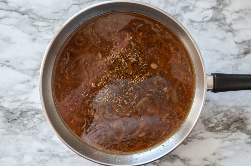 A skillet with meat drippings, ready to make au jus