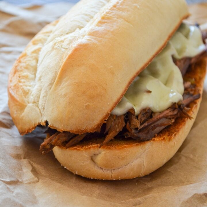 A french dip sandwich, resting on some brown paper.