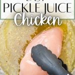 A chicken breast being dipped into a bowl of pickle brine.