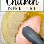 A chicken breast being dipped into pickle juice.