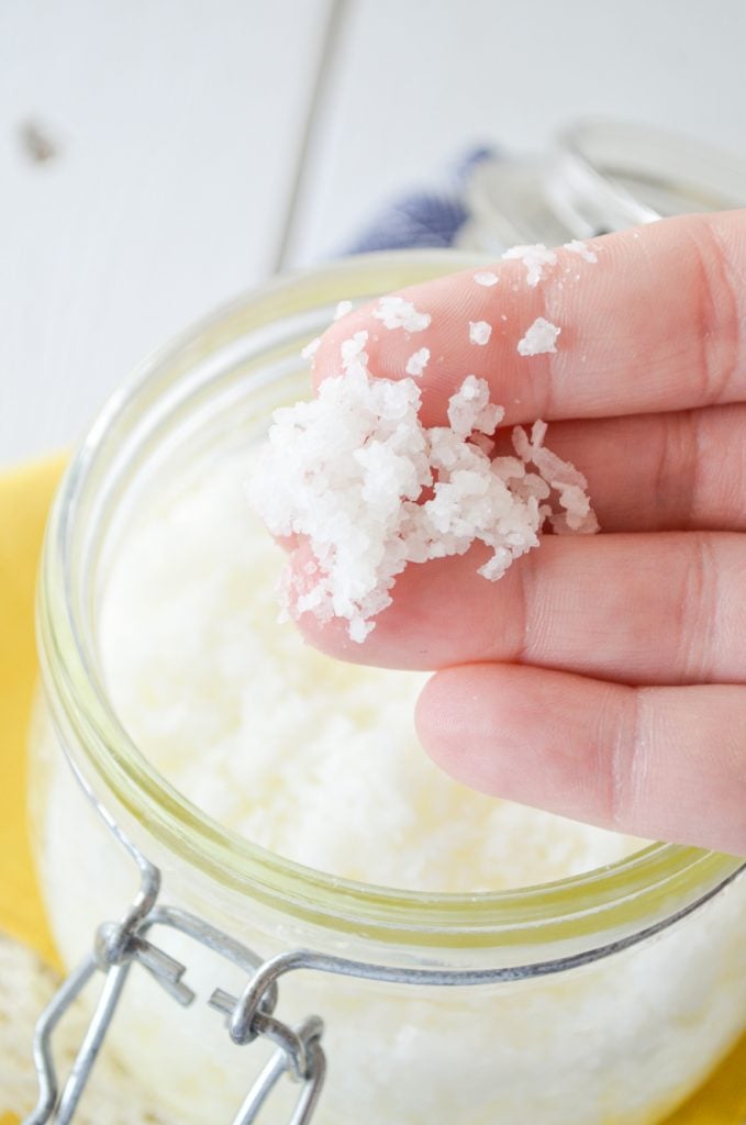 A hand with some salt scrub on the fingertips.