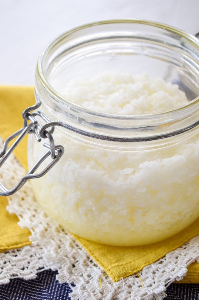 A jar of facial salt scrub, resting on a bright yellow napkin.