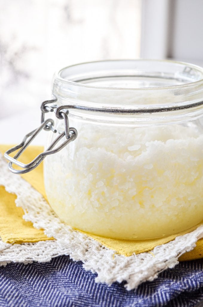 A jar of facial salt scrub resting on a bright yellow napkin.