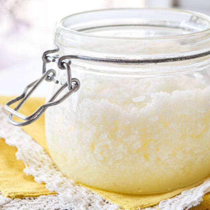 A jar of facial salt scrub resting on a bright yellow napkin.