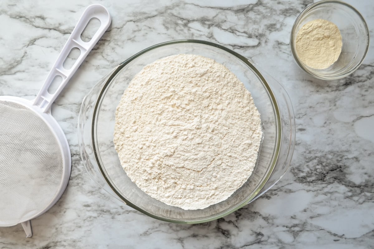 The ingredients needed to make your own bread flour: flour and vital wheat gluten. A fine mesh strainer as well.