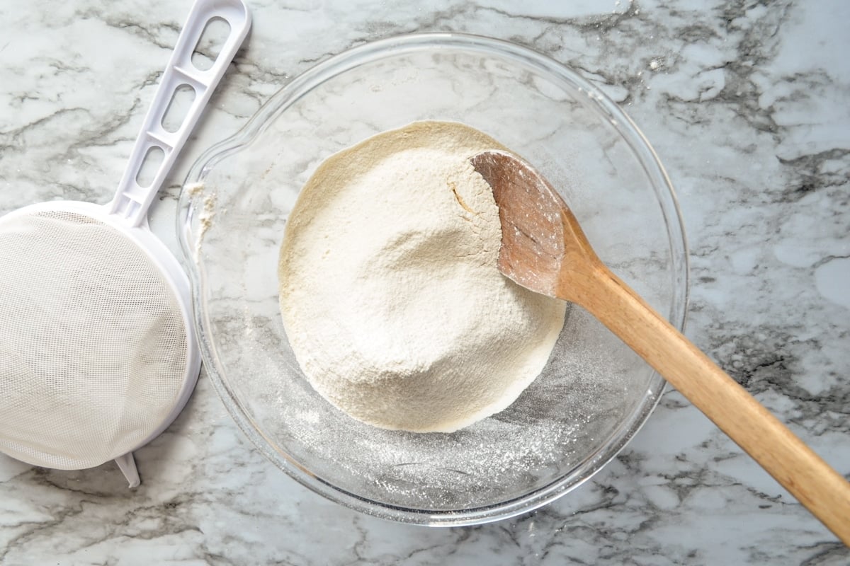 Sifted flour and wheat gluten in a large glass bowl.