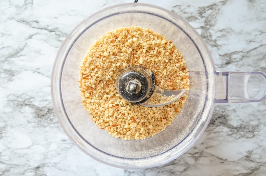 A top down view of a food processor with breadcrumbs inside.