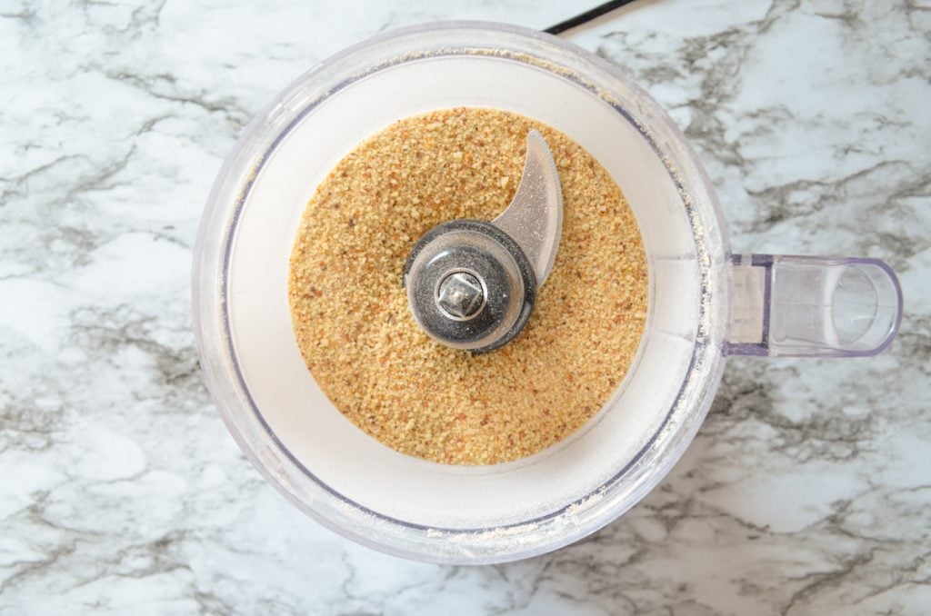 A top down view of a food processor with sourdough breadcrumbs inside.