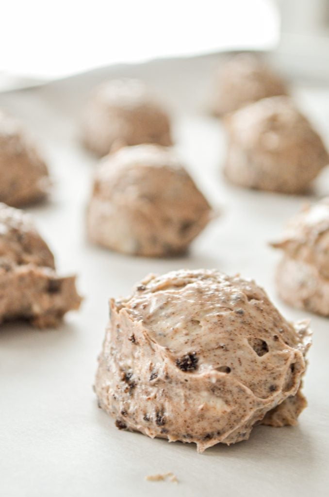 Oreo cheesecake bites, spooned onto a parchment lined baking sheet.