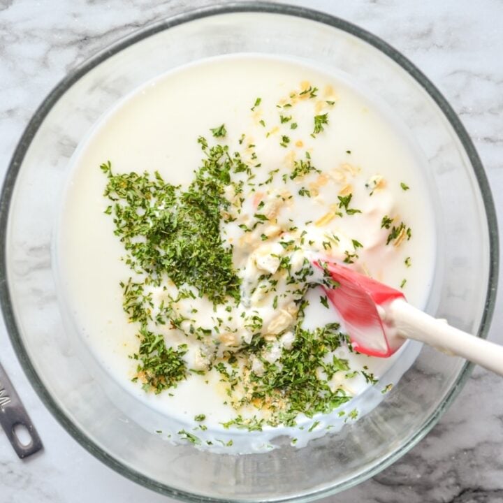 A bowl of ingredients for making buttermilk ranch salad dressing from scratch.