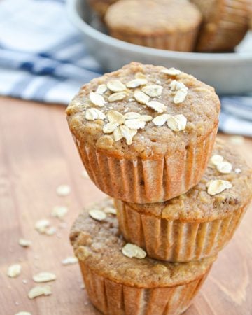A stack of three muffins with oats sprinkled on top.