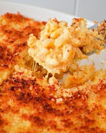 A close up of macaroni and cheese coming out of a casserole dish.
