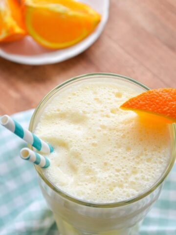 A glass of copycat Orange Julius with a garnish wedge of fresh orange.