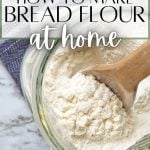 A spoon going into a large jar of homemade bread flour.