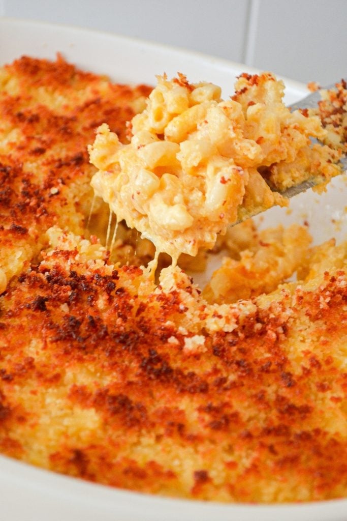 A homemade macaroni and cheese casserole, with a piece being removed.