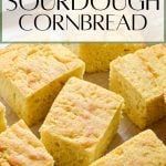 Squares of cornbread with a light crust. Text overlay reads: sourdough cornbread.