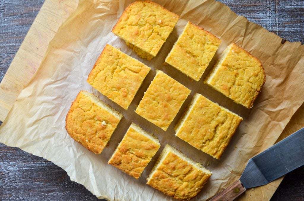 An overhead view of sourdough cornbread, cut into 9 squares.