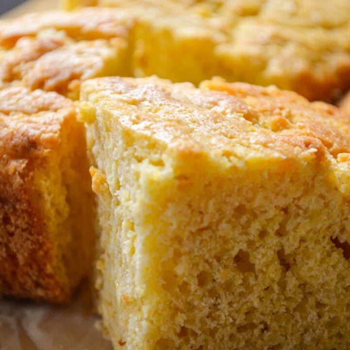 A close up of buttermilk cornbread on a parchment paper surface.