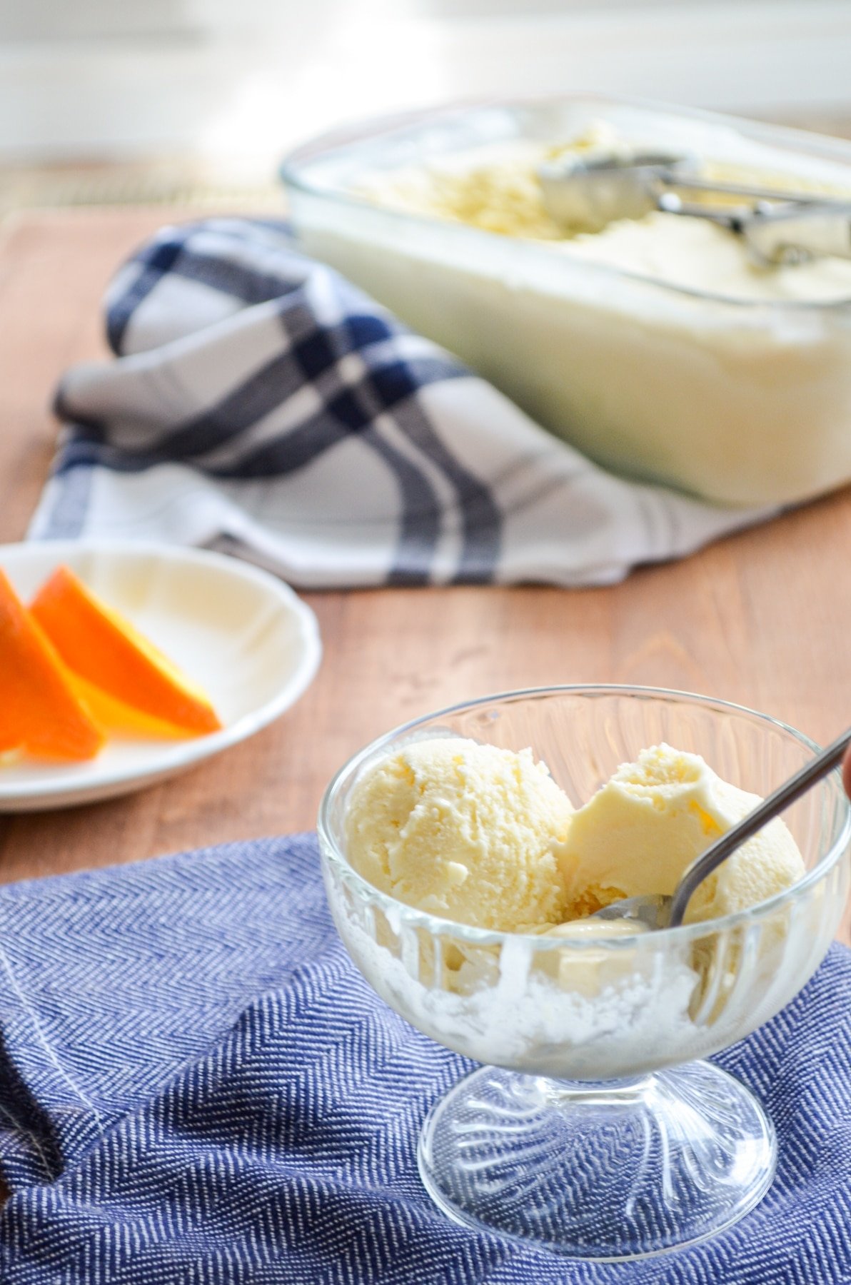 A small glass dish of orange creamsicle ice cream.