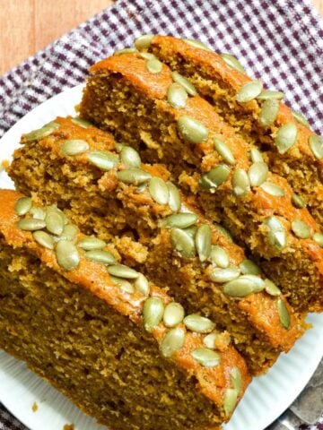 Slices of sourdough pumpkin loaf, sprinkled with pepitas.