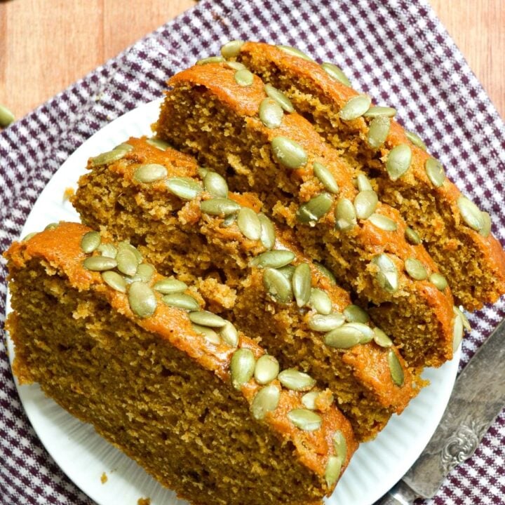 Slices of sourdough pumpkin loaf, sprinkled with pepitas.