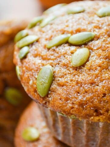 A sourdough pumpkin muffin, topped with pepitas.