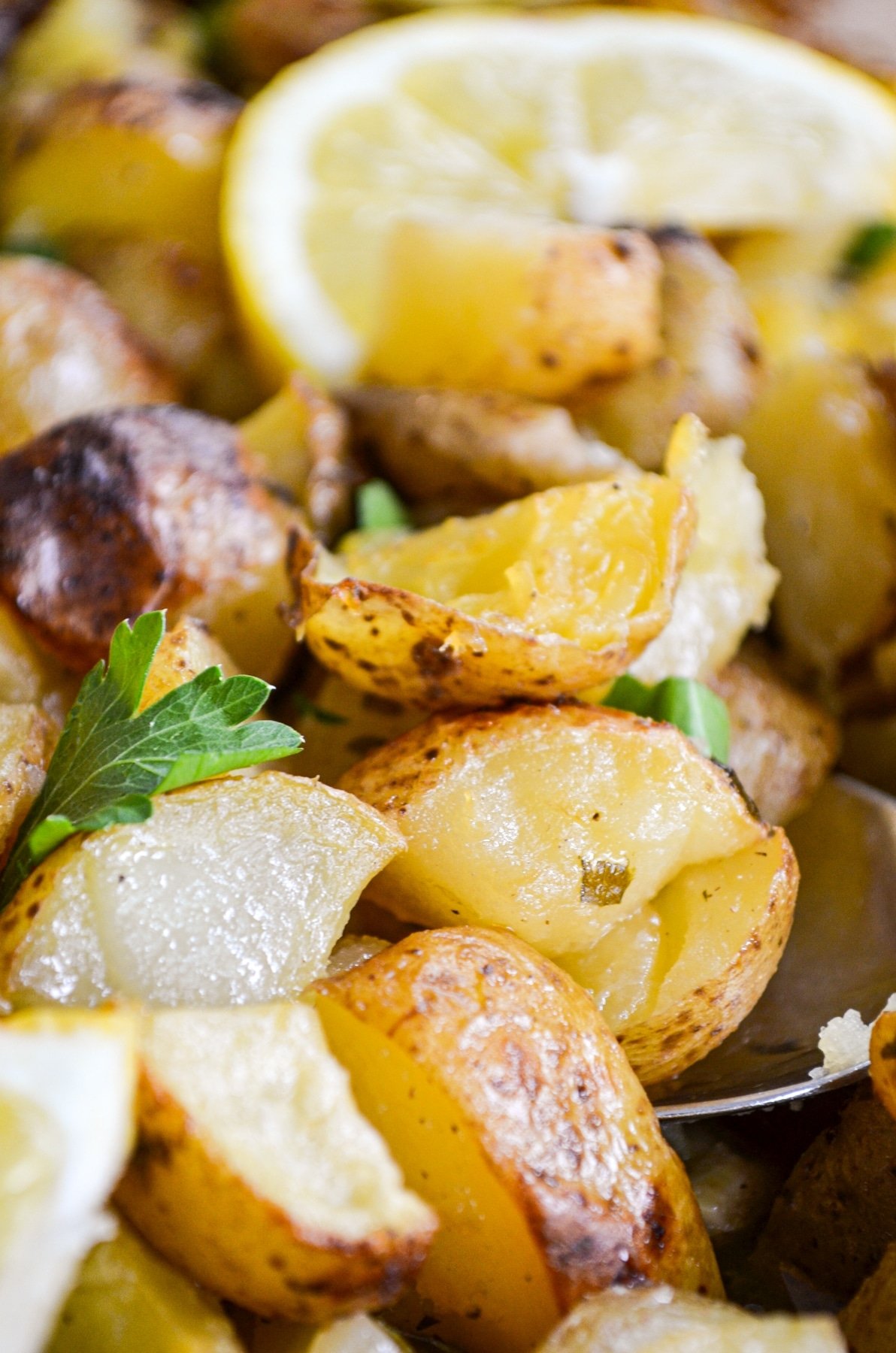 A scoop of roasted potatoes, with a garnish of lemon.