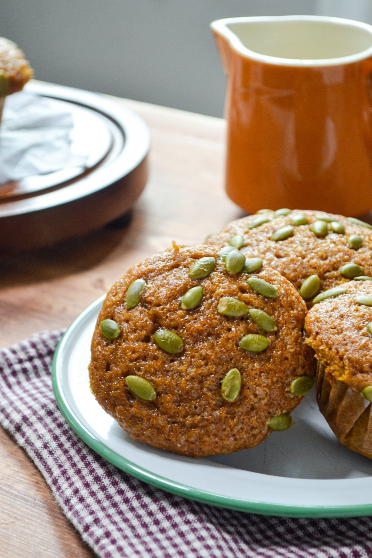 A plate of muffins, with a small cruet in the background.